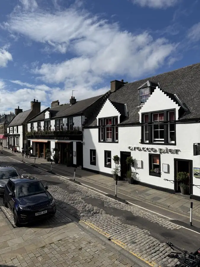 White painted hospitality venue frontage on the cobbled high street in South Queensferry