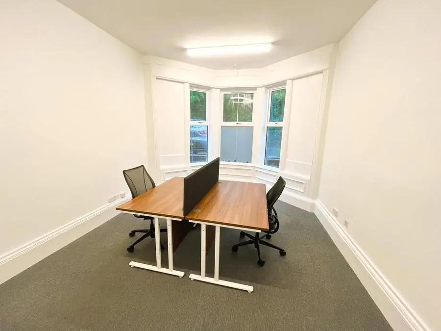Office with a bay window, bright white walls and desks
