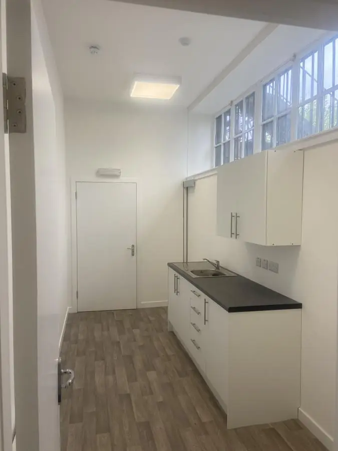Office kitchen area with freshly painted white walls and fitted units