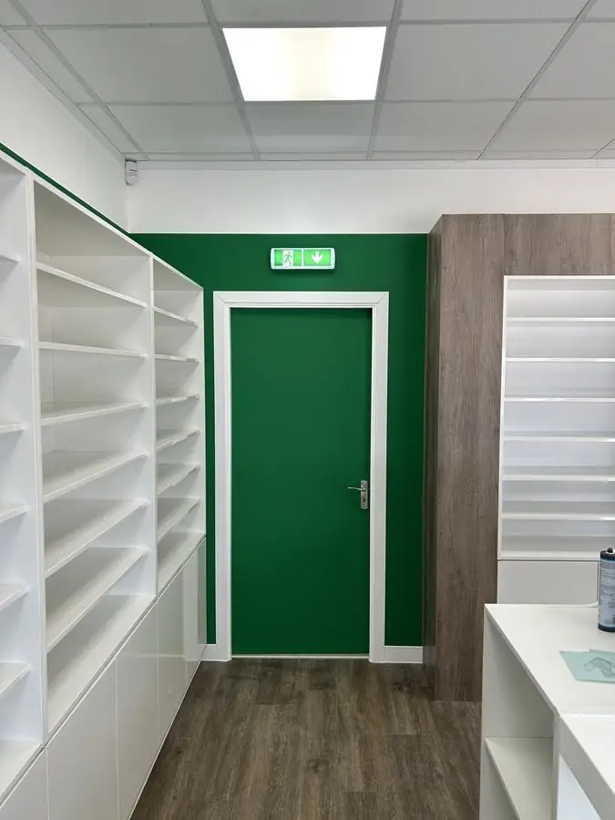 Retail unit with a deep green painted wall and matching door