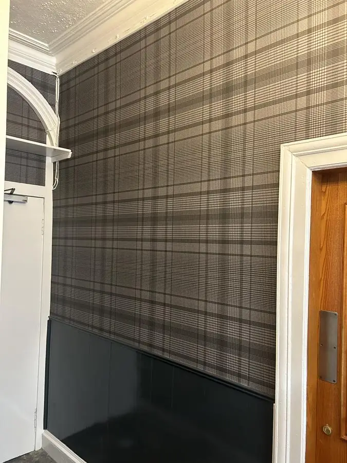 Tartan wallpaper pattern-matched around a doorway and architrave