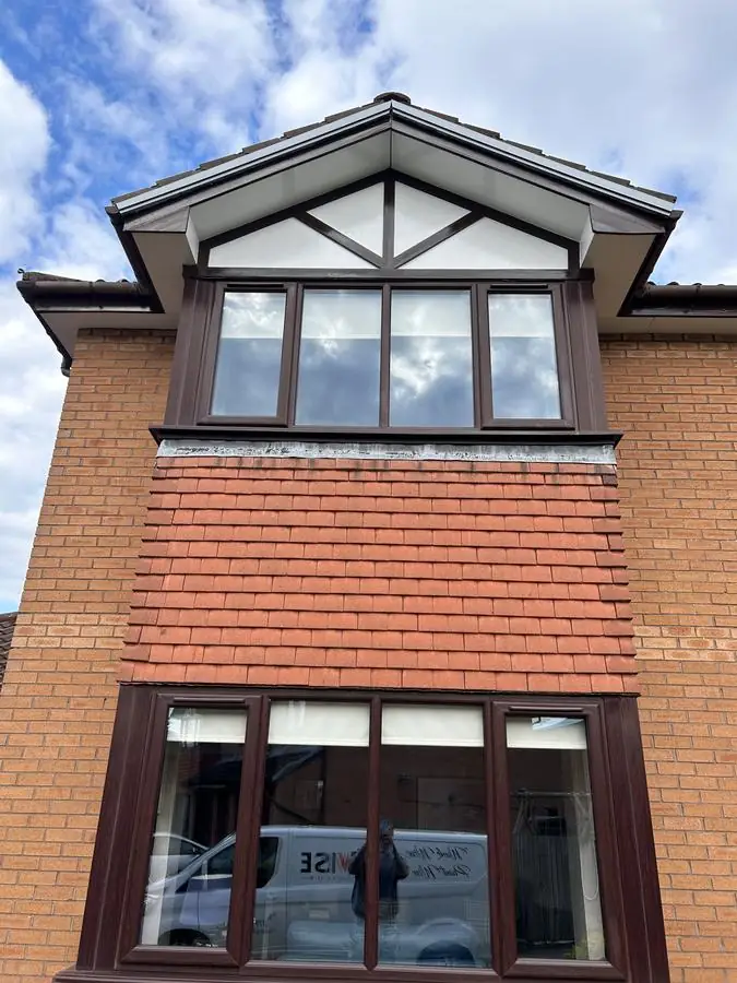 Brick house with a repainted dark brown fascia and white soffits